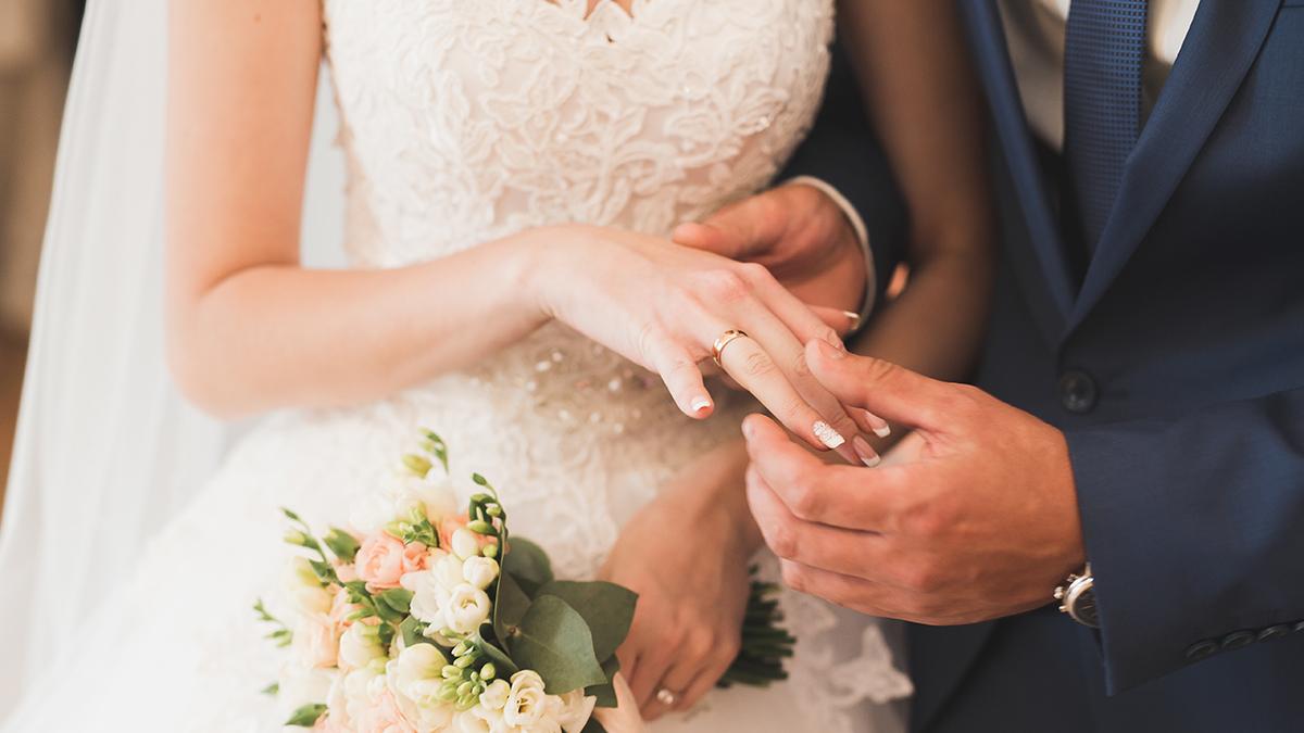 Bride and groom exchanging wedding rings. Stylish couple official ceremony